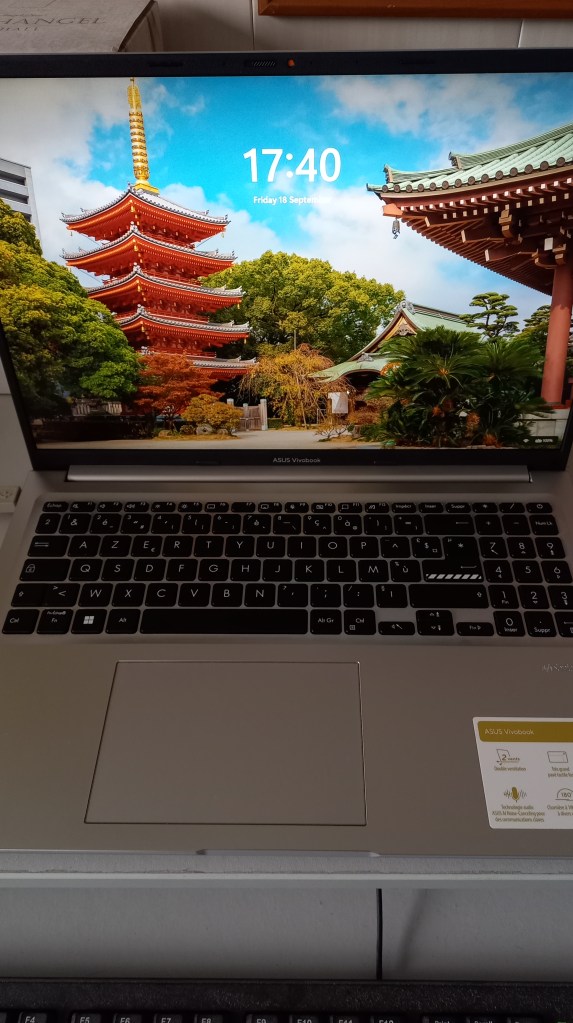 colour photograph of a modern laptop, its screen up and open to show an internet image, with the key pad in the foreground.